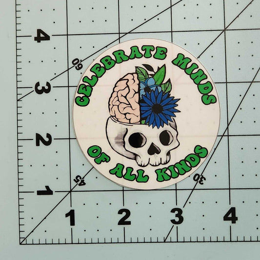 Circular sticker with skull design and text on a cutting mat with ruler