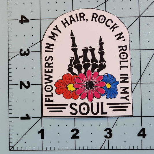 Sticker with text and floral design on a cutting mat with measurements.