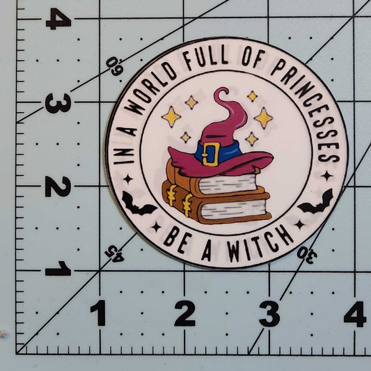 Sticker with a witch hat design on a cutting mat with measurements.