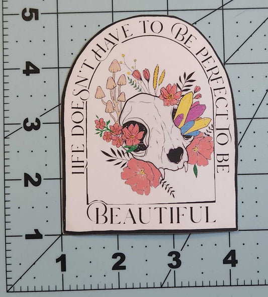 Decorative sticker with floral design and text on a cutting mat with ruler