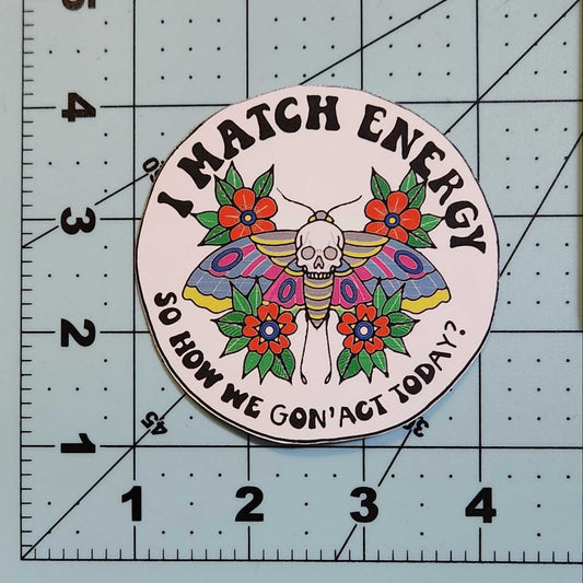 Circular sticker with butterfly design and text on a cutting mat
