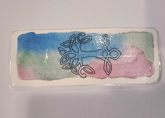 Decorative rectangular object with Celtic knot design on a colorful background