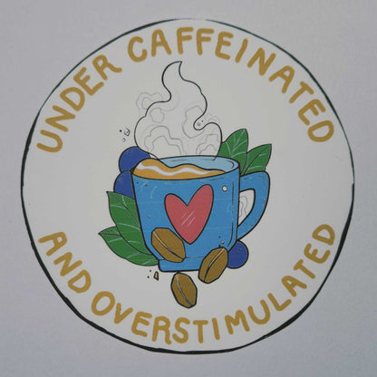Circular logo with text 'Under Caffeinated and Overstimulated' featuring a coffee cup and heart design on a white background.