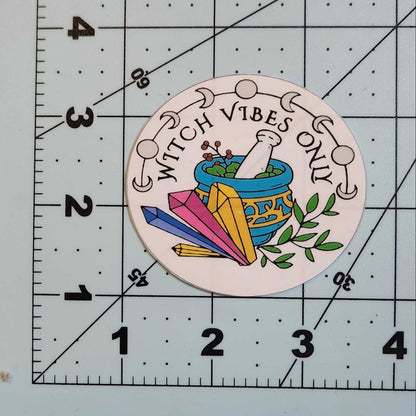 Circular sticker with 'Witch Vibes Only' text and colorful design on a ruler.